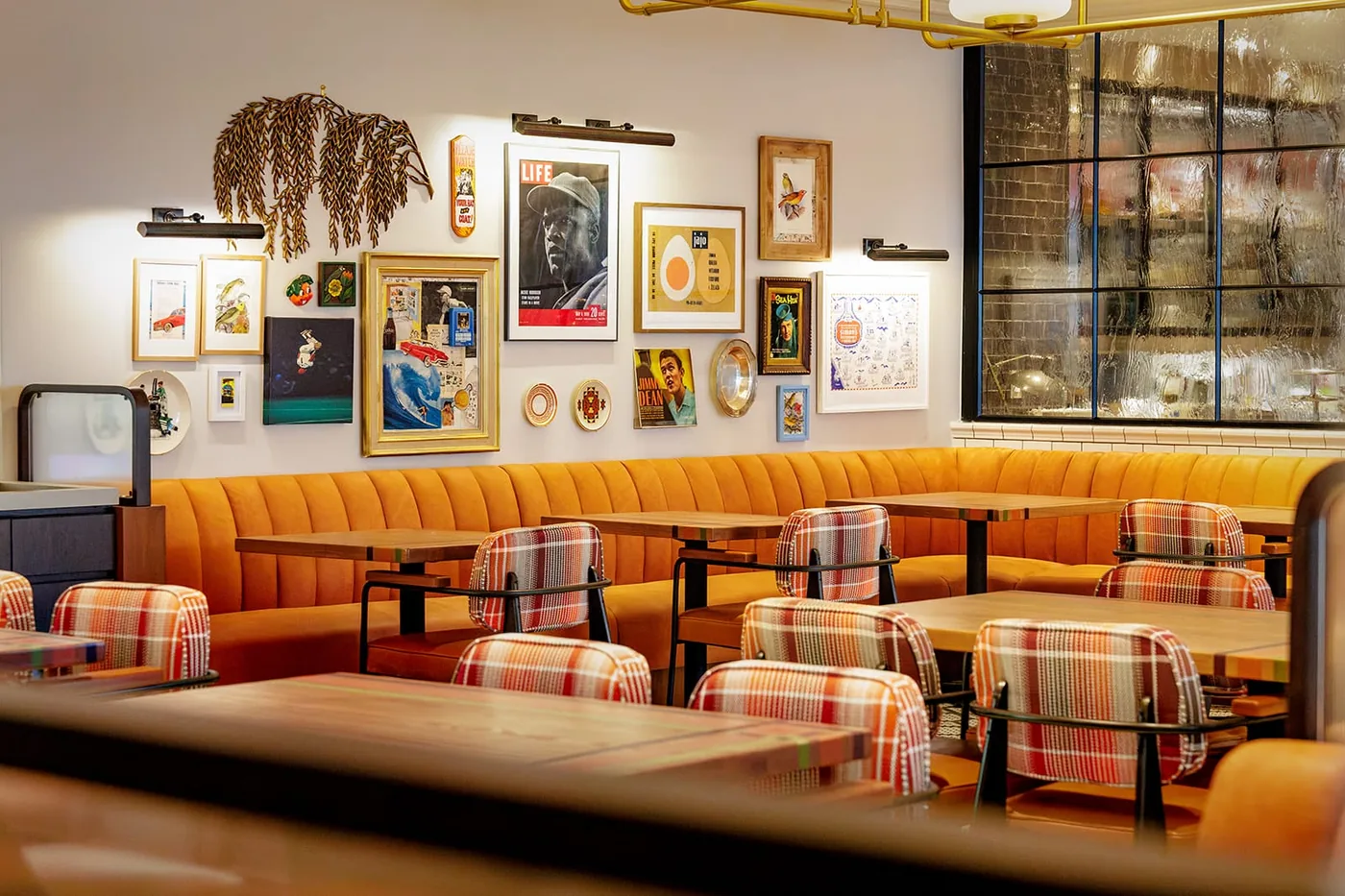 Mustard banquettes and plaid chairs in the dining room at Birdie G's