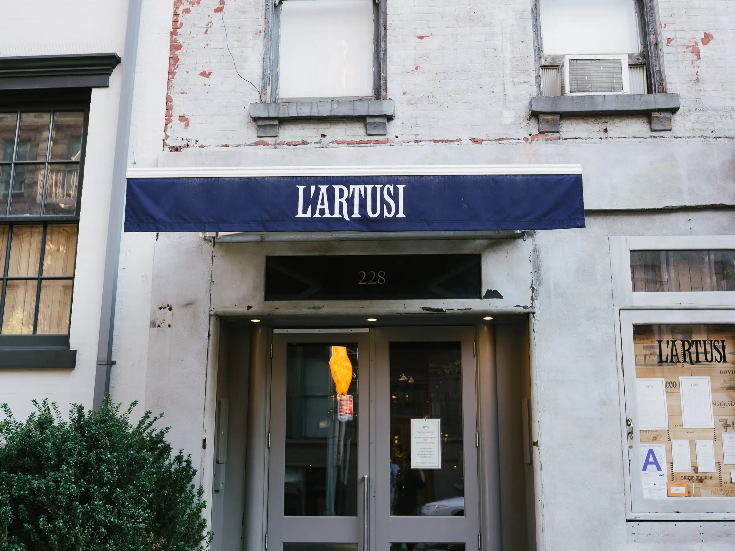The navy L'Artusi awning above the restaurant's front doors