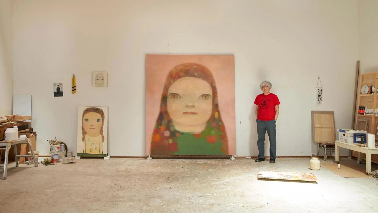 Yoshitomo Nara in his studio beside a large painting
