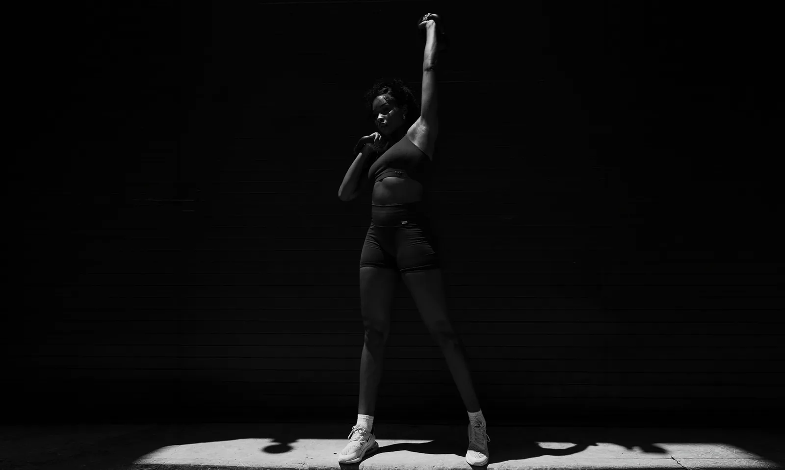 A Dogpound athlete under a single spotlight