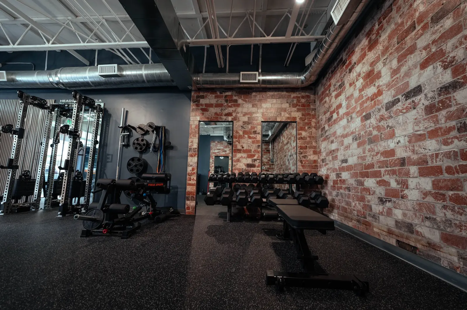 The training floor at HQ LA, brick wall and racks under low light