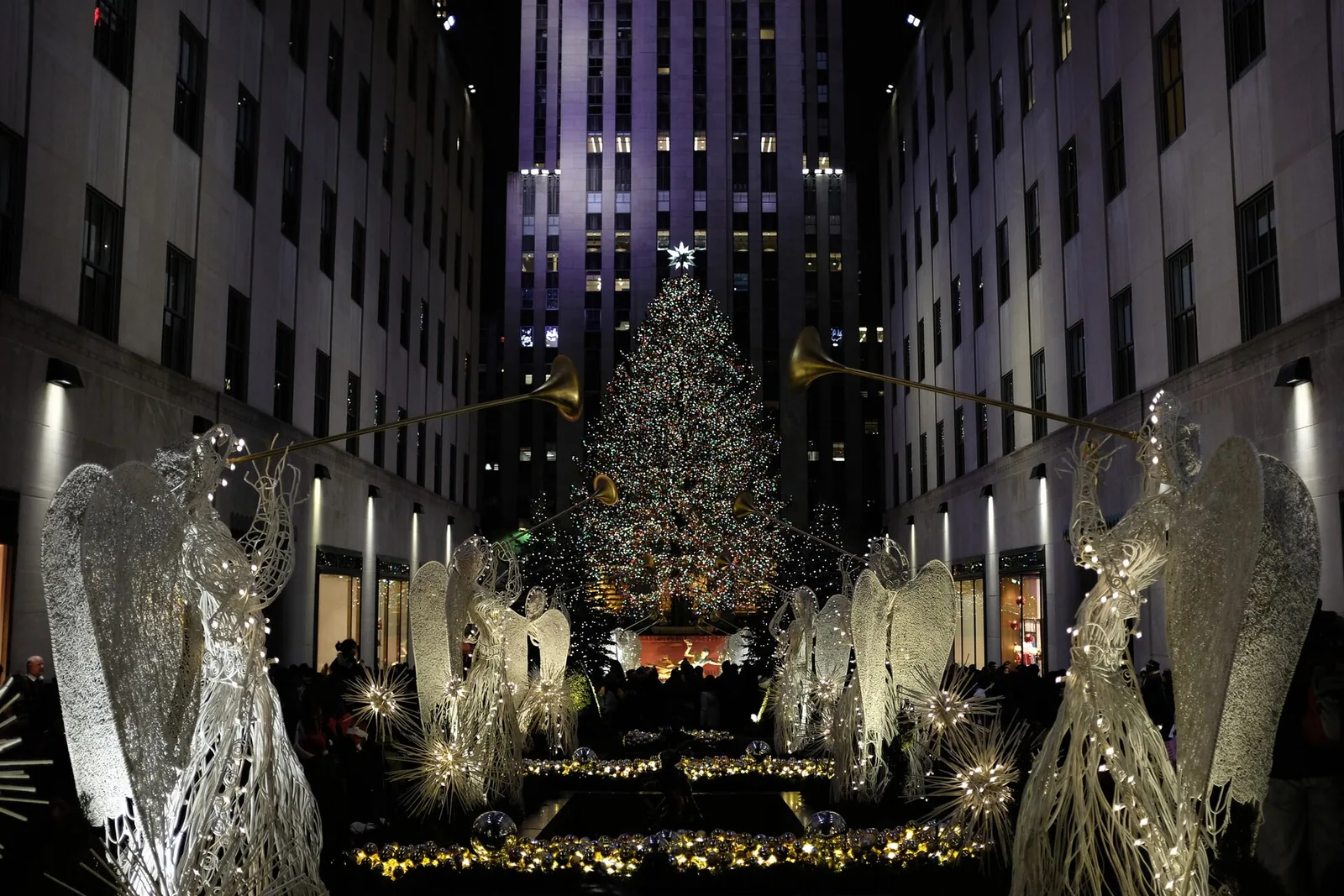 The Rockefeller Center Christmas Tree at night, framed by the Channel Gardens angels