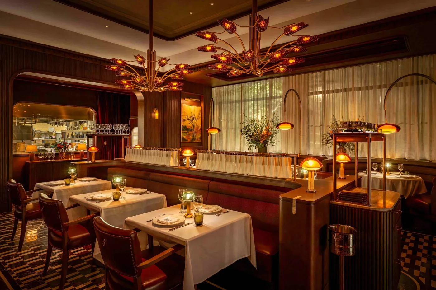 The dining room at Spacca Tutto, lamps lit over white tablecloths